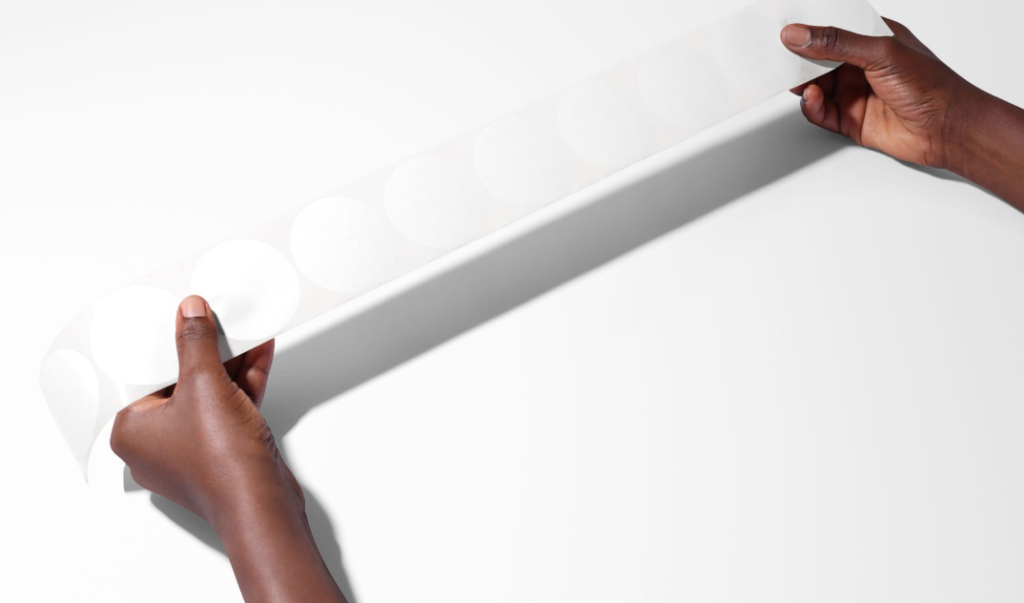 Round Sticker Tape Held in Hands PSD Mockup